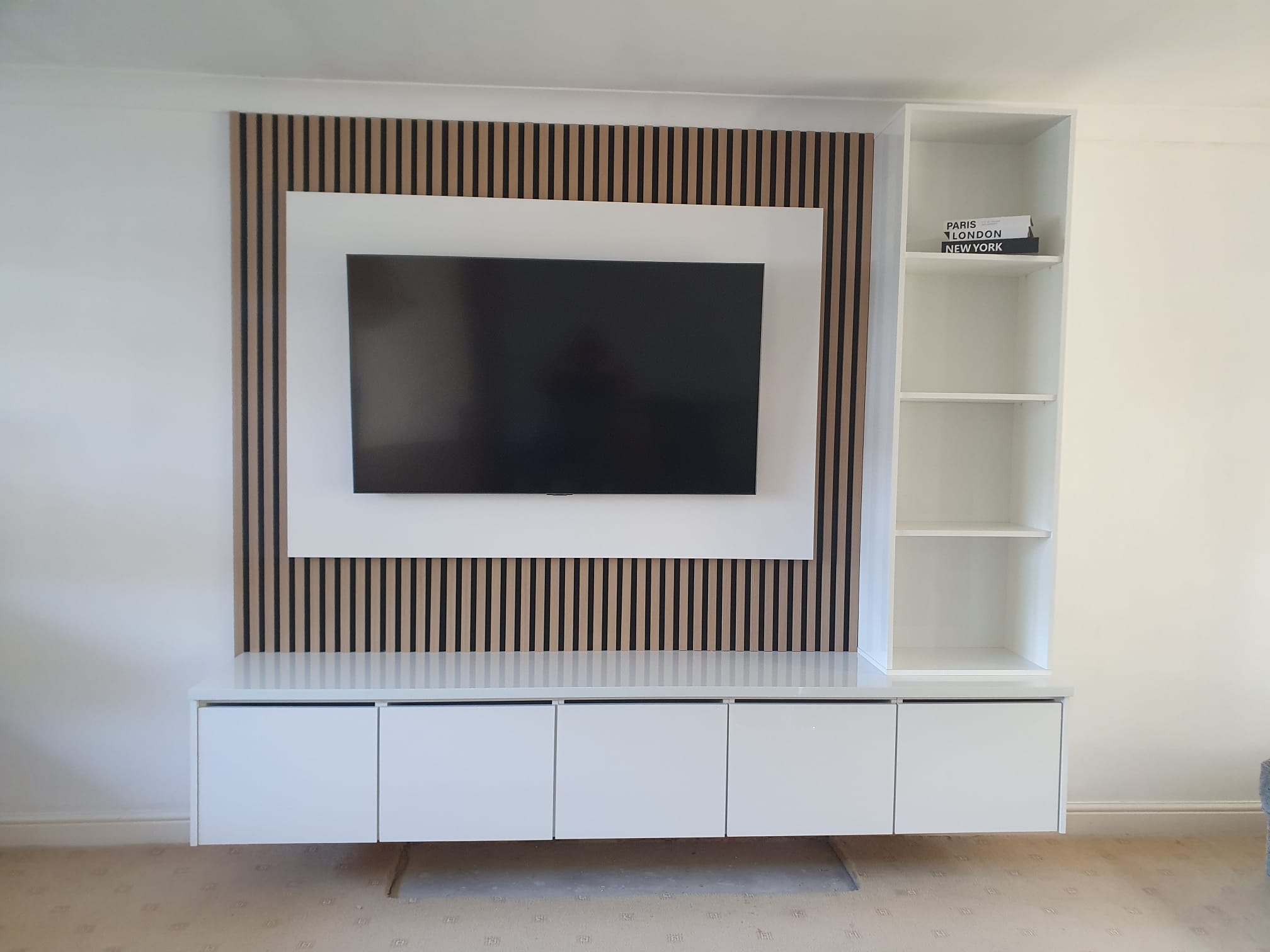 Bespoke media wall with oak slat feature panel, floating white gloss unit and matching bookcase
